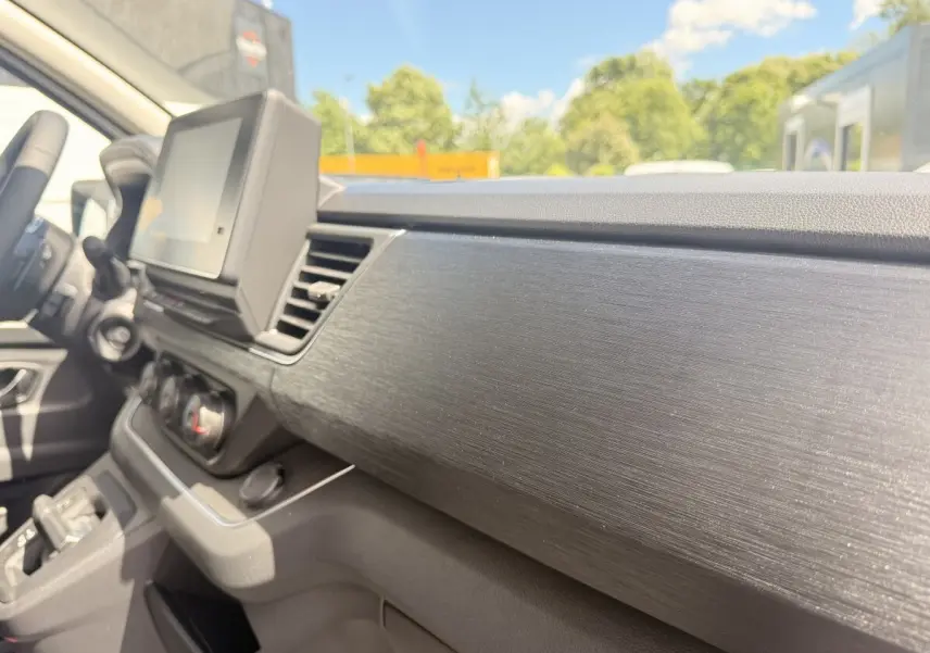 Vue intérieure côté passager du tableau de bord noir texturé du Renault Trafic Fourgon blanc 2025.