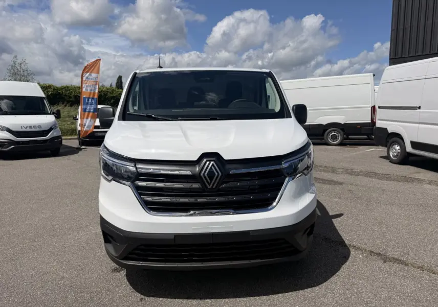 Renault Trafic Fourgon blanc vu de face, avec calandre noire et logo Renault bien visible.