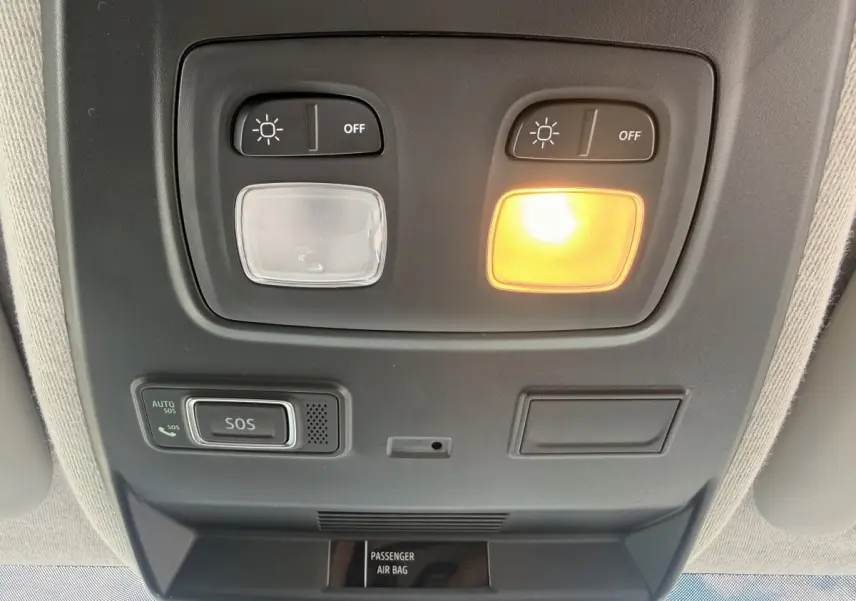 Vue en contre-plongée du plafonnier intérieur du Renault Trafic blanc avec éclairage et bouton SOS activé.