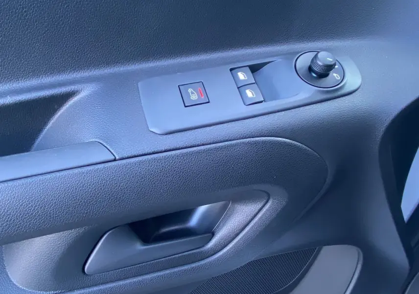 Gros plan sur la commande de vitres et rétroviseurs côté conducteur du Peugeot Partner blanc 2024.