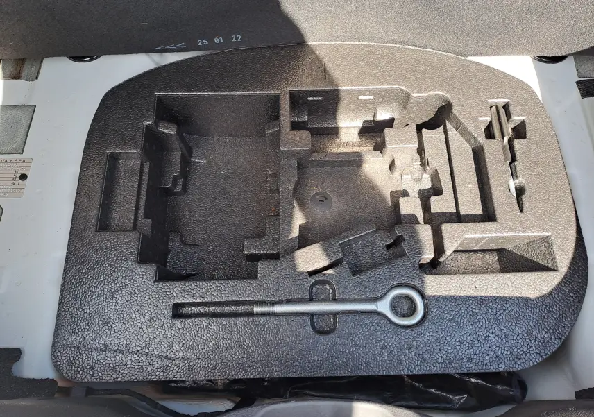 Coffrage en mousse noire pour outils de bord sous le coffre d'une Fiat 500 blanche 2022, version hybride.