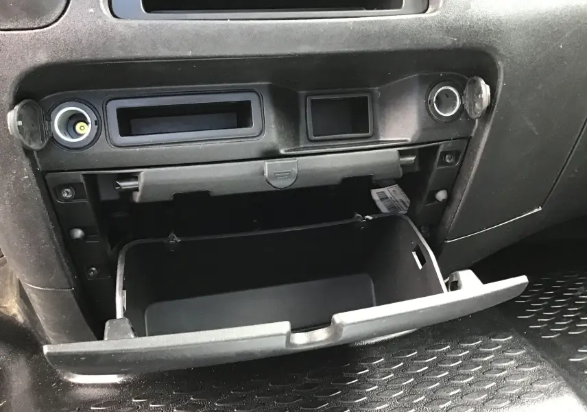 Gros plan sur la boîte à gants ouverte de l'IVECO Daily Châssis double cabine 2021, intérieur noir.