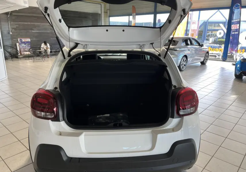 Vue arrière d'une Citroën C3 blanche 2024 avec coffre ouvert et feux arrière à effet 3D en showroom.