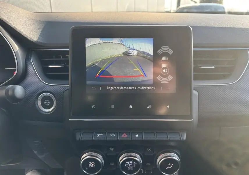 Vue intérieure du tableau de bord de Renault Arkana gris, écran tactile affichant la caméra de recul en marche.