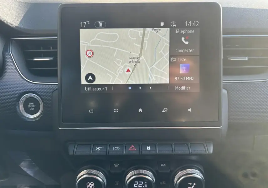 Vue centrale du tableau de bord de la Renault Arkana 2025 avec écran tactile GPS et commandes climatisation digitales.
