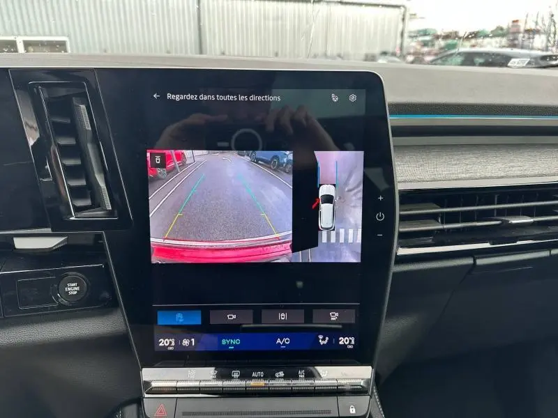 Vue intérieure du tableau de bord du Renault Austral 2025, écran central affichant la caméra de recul avec vue arrière du véhicule rouge flamme.