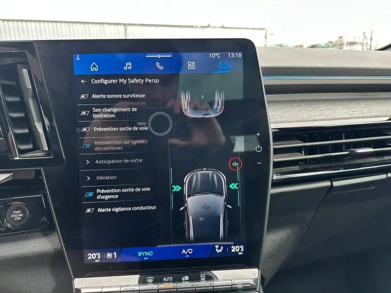 Vue rapprochée de l’écran tactile central du Renault Austral 2025 Rouge Flamme affichant les options d’aide à la conduite.