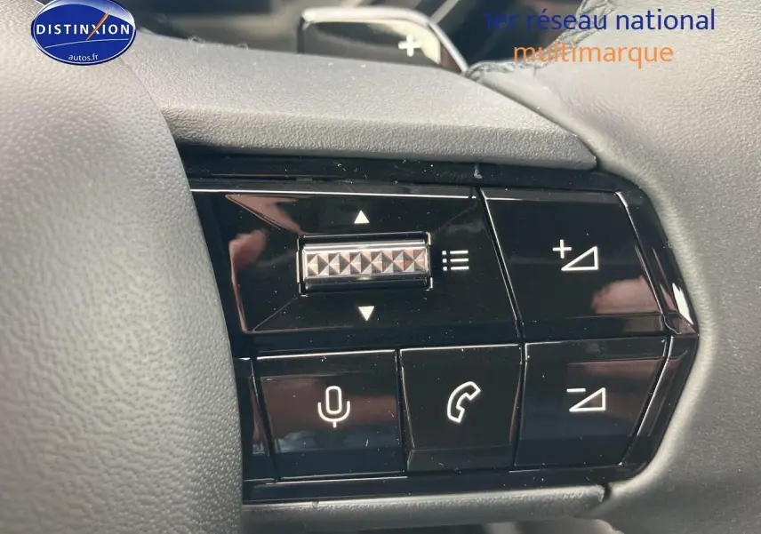 Gros plan sur les commandes au volant noir de l'Alfa Romeo Junior 1.2 hybride 2026, avec boutons de volume et appels.