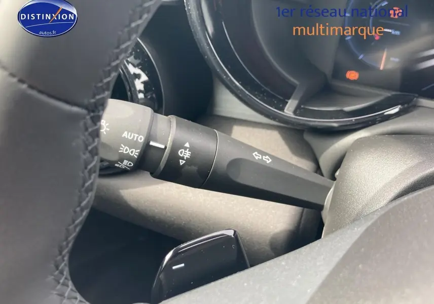 Détail du commodo d’éclairage et clignotants sur le côté gauche du volant d’une Alfa Romeo Junior 1.2 hybride rouge/noir.