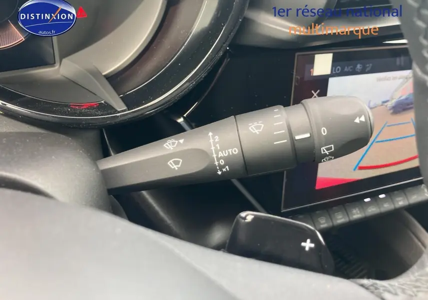 Détail du commodo d’essuie-glace dans l’habitacle d’une Alfa Romeo Junior 1.2 hybride rouge/noir, avec écran tactile et caméra de recul.