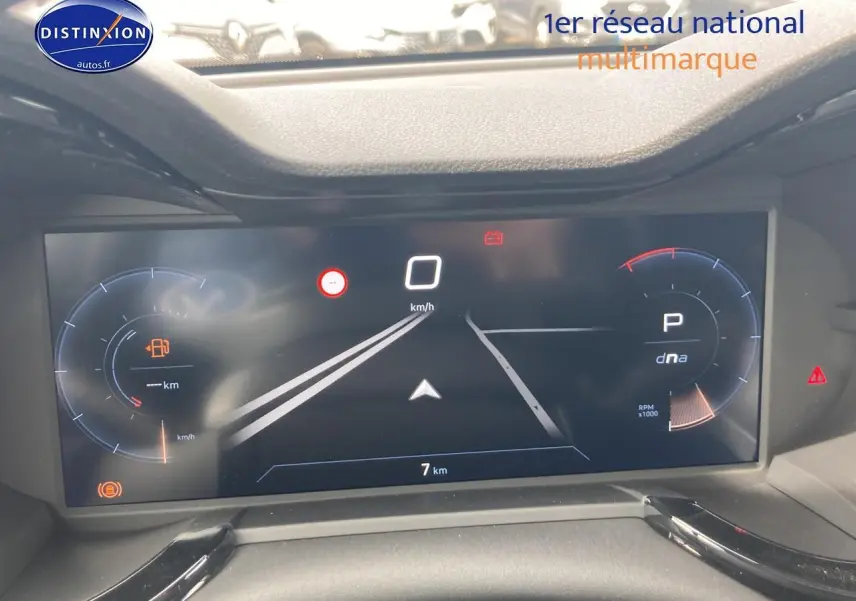 Tableau de bord numérique de l'Alfa Romeo Junior 1.2 hybride, affichage vitesse et mode de conduite, vue frontale rapprochée.