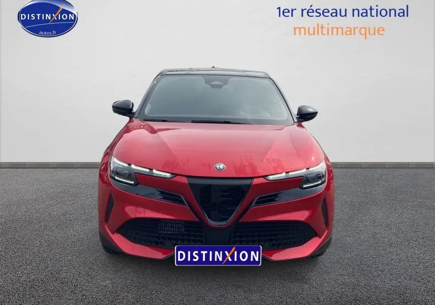 Vue frontale d'une Alfa Romeo Junior 1.2 hybride rouge et noir avec calandre noire et phares LED fins.