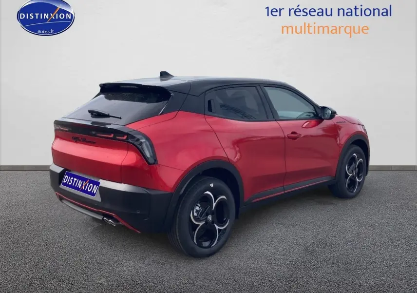 Vue 3/4 arrière droite d'une Alfa Romeo Junior 1.2 hybride rouge et noir avec jantes en alliage et toit noir.