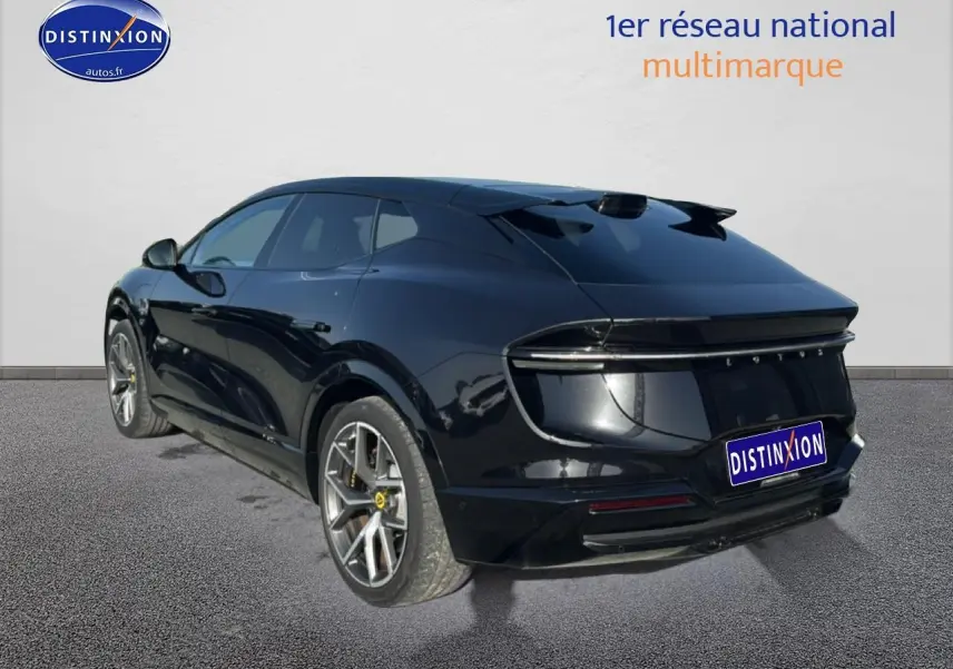 Vue 3/4 arrière droite d'une Lotus Eletre noire 2023 avec jantes alu et feux arrière LED continus.