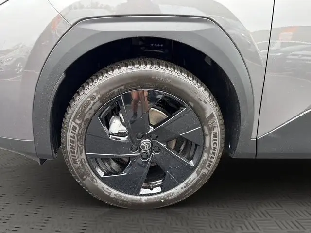 Gros plan sur la roue arrière droite d'une Citroën C5 hybride gris foncé, avec jante noire et pneu Michelin visible.