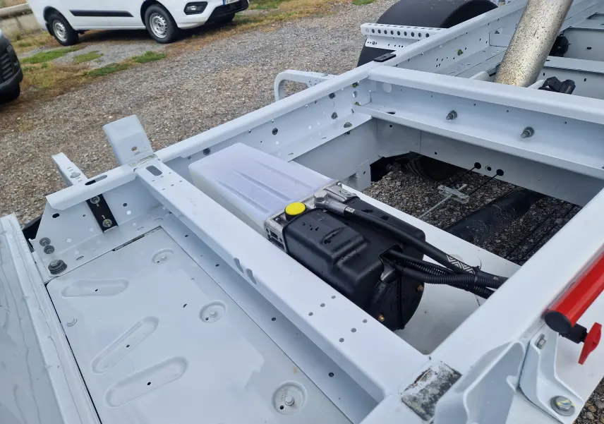 Vue rapprochée du châssis blanc du Renault Master Benne L2, montrant la structure métallique et le réservoir sous la benne.