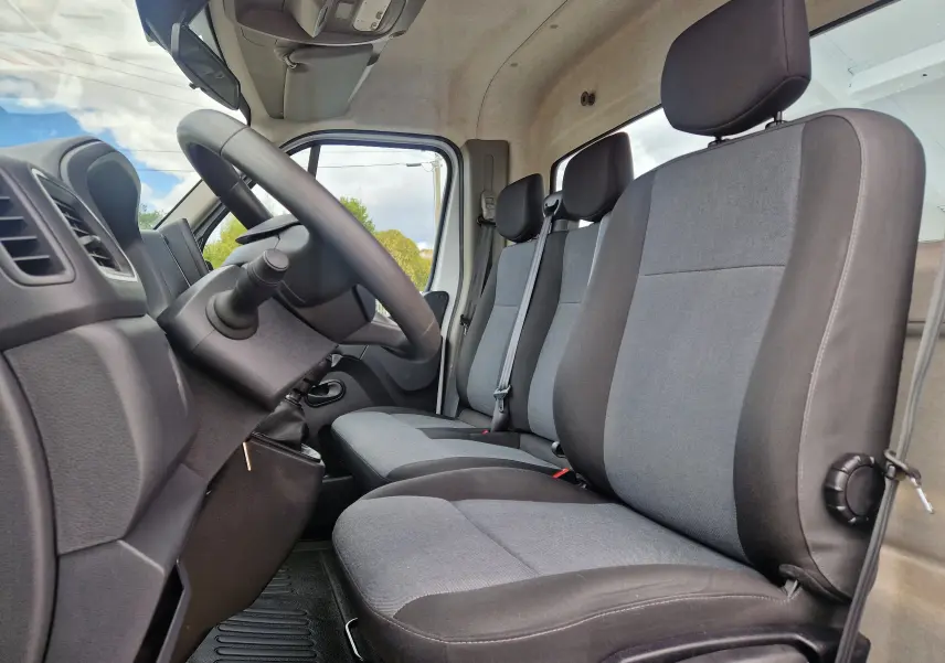 Vue intérieure côté conducteur du Renault Master Châssis Cabine 2024, montrant les sièges gris et noirs et le volant.