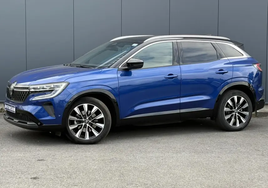 Vue de profil côté gauche du Renault Austral E-Tech en bleu Iron avec toit noir panoramique et jantes alliage 19 pouces.