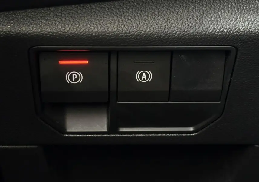 Gros plan sur les boutons de frein de parking électrique et auto-hold dans l’habitacle du Renault Austral 2025.