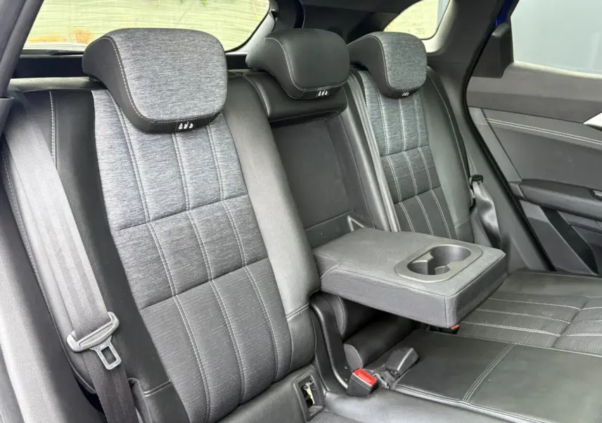 Vue intérieure de la banquette arrière du Renault Austral E-Tech, sellerie mixte gris avec accoudoir central rabattable.