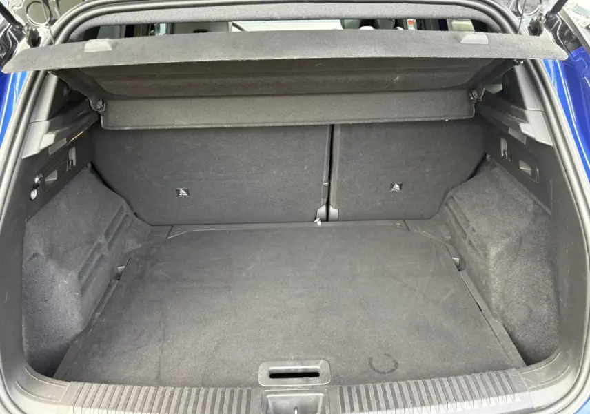Coffre ouvert vu de l'arrière d'un Renault Austral Bleu Iron, montrant un espace de chargement vide et propre.