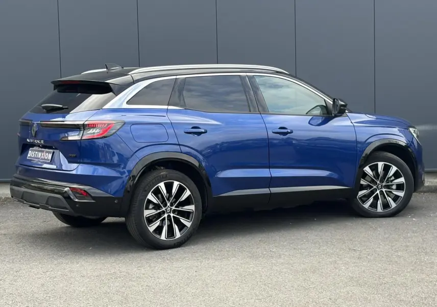 Vue de profil côté droit du Renault Austral E-Tech Full Hybrid 200 Techno bleu Iron avec toit panoramique et jantes alliage noires.