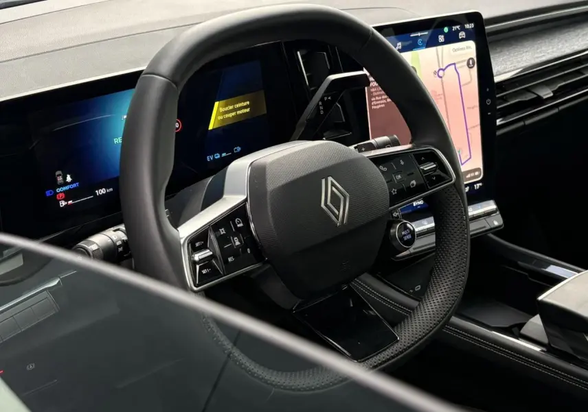 Vue rapprochée du volant noir et du tableau de bord digital du Renault Austral E-Tech 2025 avec écran tactile vertical.