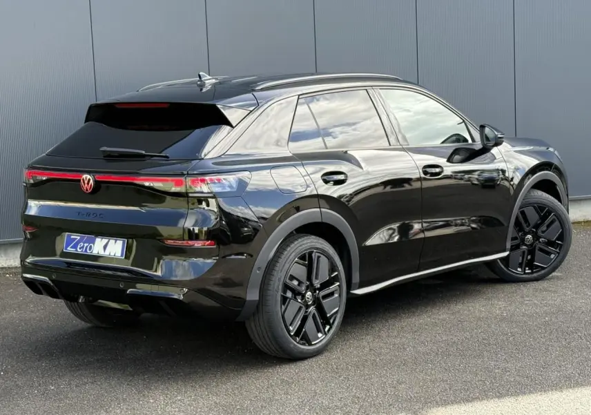 Volkswagen T-Roc noir ébène en 3/4 arrière droit, avec jantes noires sport et vitres surteintées.