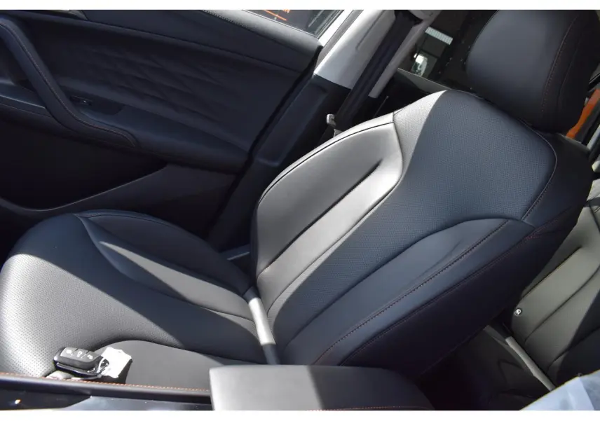 Gros plan sur le siège avant droit en cuir noir avec surpiqûres marron du MG MOTOR EHS blanc 2026, version Hybrid+ Luxury.