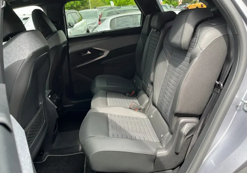 Vue intérieure côté droit des sièges arrière en tissu et cuir du Peugeot 3008 Hybrid 2025 gris artense avec toit noir.