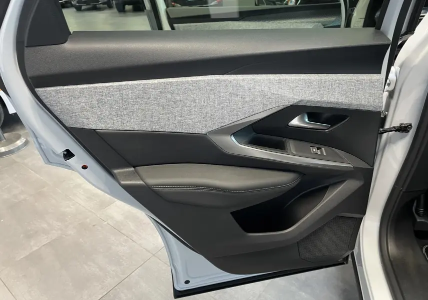 Porte arrière gauche ouverte du Peugeot 3008 blanc Okenite, montrant le décor tissu gris chiné et les commandes de vitre.