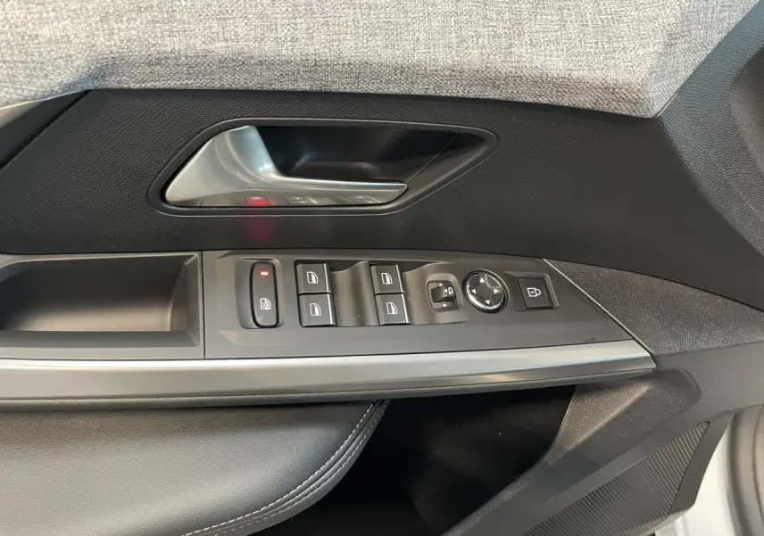 Gros plan sur la porte avant gauche du Peugeot 3008 blanc Okenite, montrant les commandes des vitres et rétroviseurs.