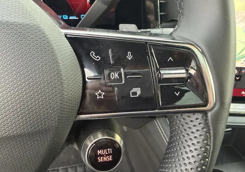 Gros plan sur les commandes au volant et le bouton Multi-Sense du Renault Austral E-Tech hybride 2025, intérieur noir.