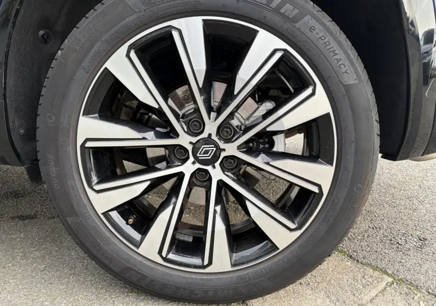 Gros plan sur la jante alliage 19 pouces Komah diamantée noire du Renault Austral E-Tech Bleu Iron.