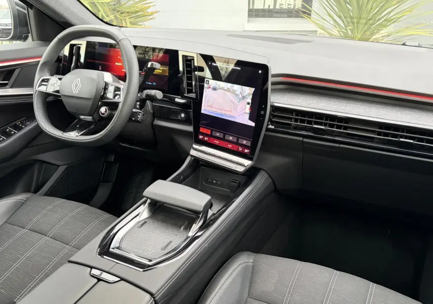 Vue intérieure avant droite du Renault Austral E-Tech 2025, tableau de bord moderne avec écran tactile vertical et volant compact.