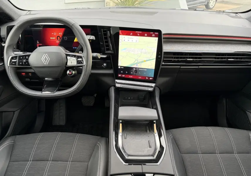 Vue intérieure avant du Renault Austral E-Tech 2025, tableau de bord noir avec écran tactile vertical et volant compact.