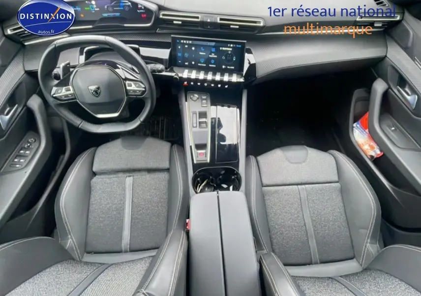 Vue intérieure frontale du poste de conduite de la Peugeot 508 SW gris artense avec volant cuir et écran tactile central.