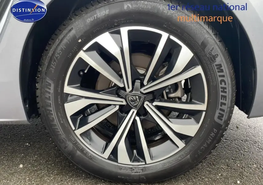 Gros plan sur la jante alu bicolore et pneu Michelin d'une Peugeot 508 SW gris Artense, côté gauche arrière.