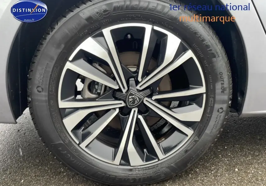 Gros plan sur la jante alu bicolore du côté gauche d’une Peugeot 508 SW gris artense hybride 2024.