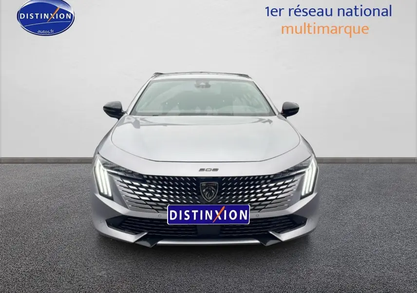 Vue avant centrée d'une Peugeot 508 SW gris artense avec calandre chromée et feux LED verticaux allumés.