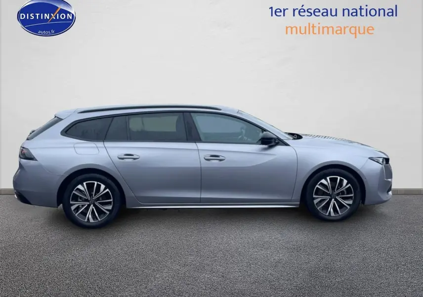 Profil droit d'une Peugeot 508 SW gris artense avec jantes alliage et barres de toit visibles.