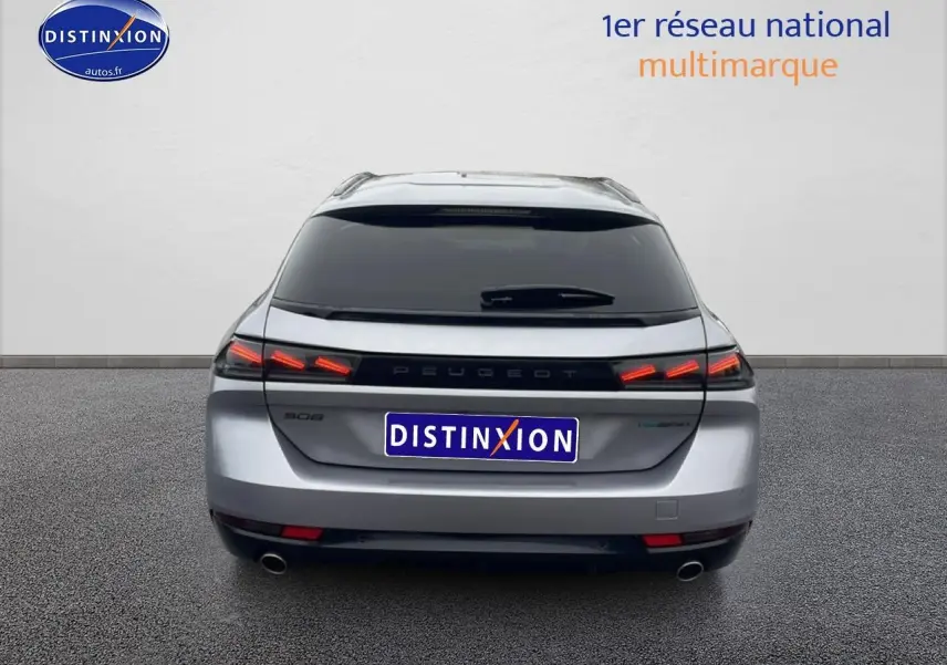Vue arrière d'une Peugeot 508 SW gris artense avec feux LED allumés et double sortie d'échappement visible.