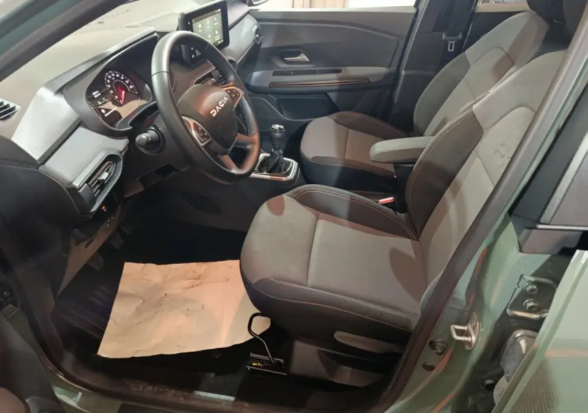 Vue intérieure côté conducteur de la Dacia Sandero Extreme+ TCe 110 2024, sièges gris et volant multifonction cuir.