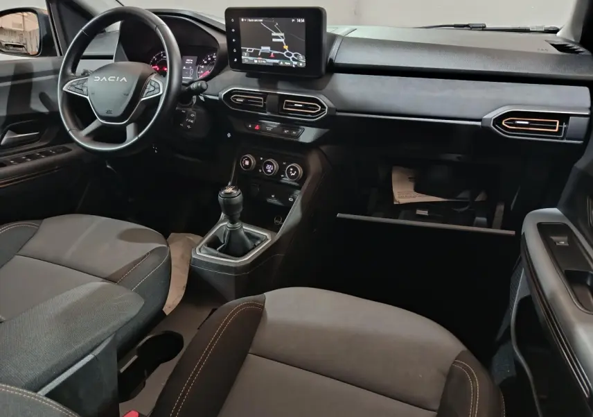 Vue intérieure avant droite du tableau de bord et volant cuir de la Dacia Sandero Extreme+ 2024 avec écran tactile et boîte manuelle.