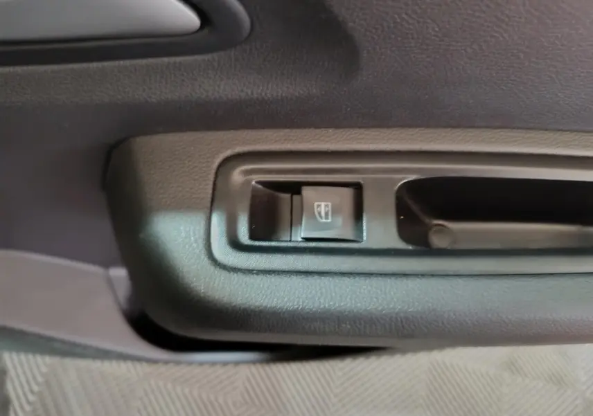 Gros plan sur le bouton de lève-vitre côté conducteur intérieur de la Dacia Sandero Extreme+ TCe 110 verte 2024.