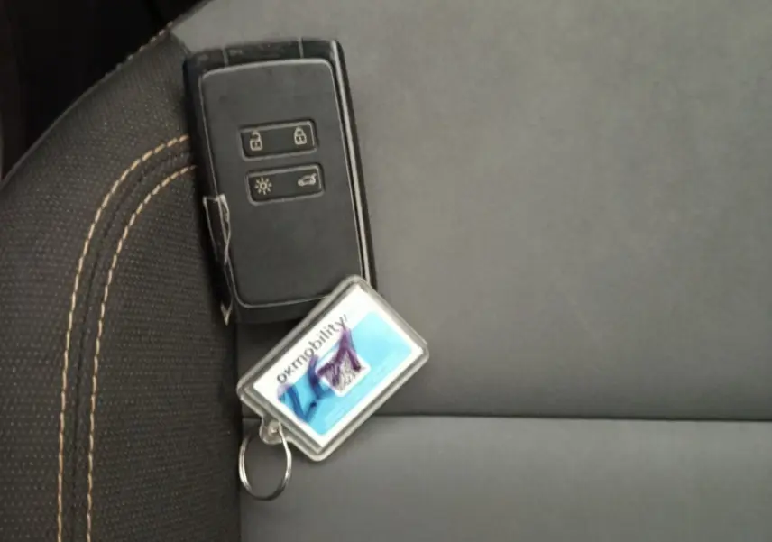 Clé de voiture noire posée sur un siège gris foncé avec surpiqûres beiges à l'intérieur d'une Dacia Sandero 2024.