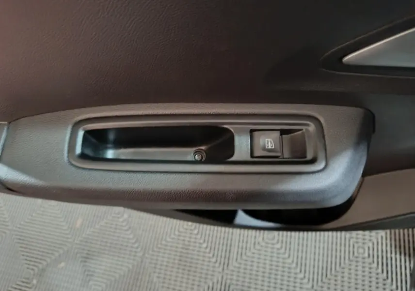 Gros plan sur la poignée intérieure de porte côté conducteur de la Dacia Sandero Extreme+ TCe 110 verte, 2024.