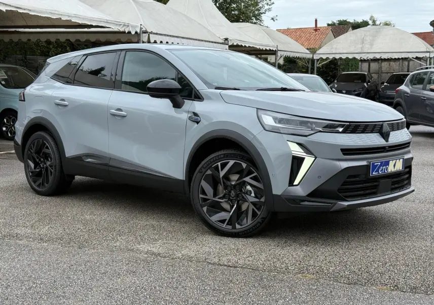 Renault Symbioz gris Rafale en vue 3/4 avant droit, avec jantes noires et feux LED distinctifs allumés.