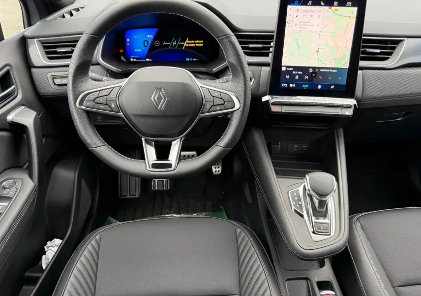 Vue intérieure centrée sur le volant Renault Symbioz 2026, tableau de bord numérique et écran tactile vertical.
