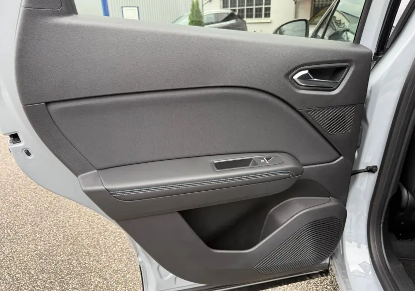 Vue rapprochée de la porte arrière droite gris rafale du Renault Symbioz 2026, avec commande de vitre et haut-parleur intégré.